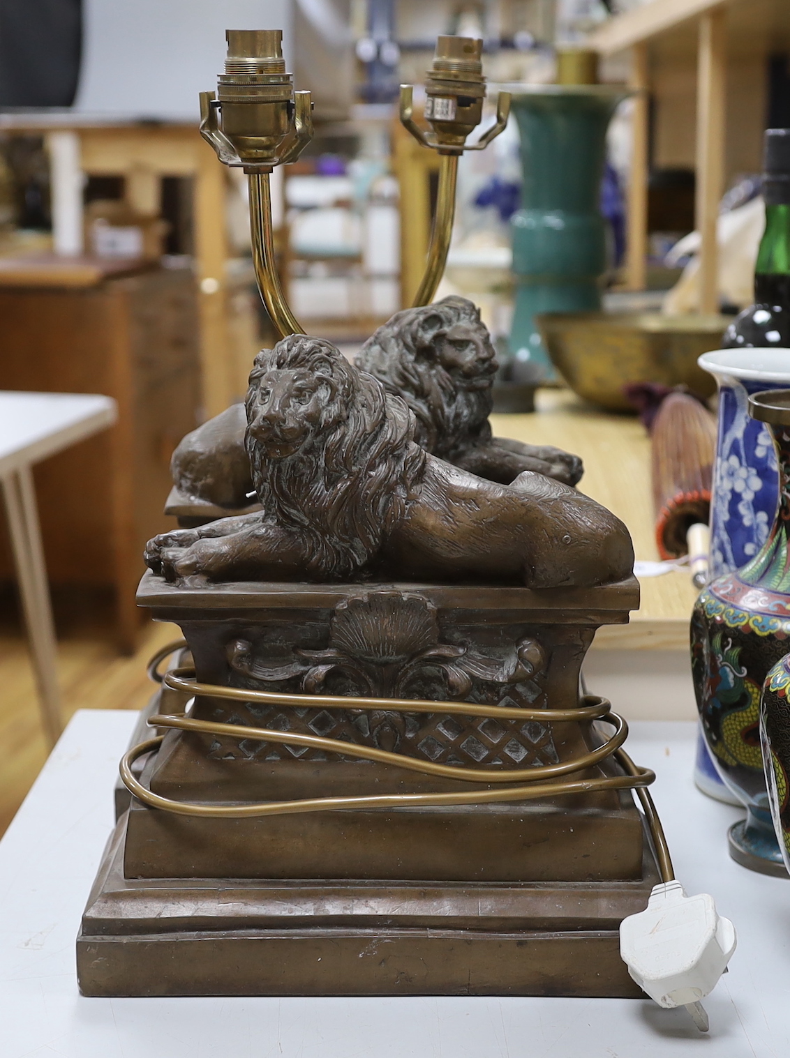 A pair of Thomas Blakemore recumbent lion table lamps, 43cm tall